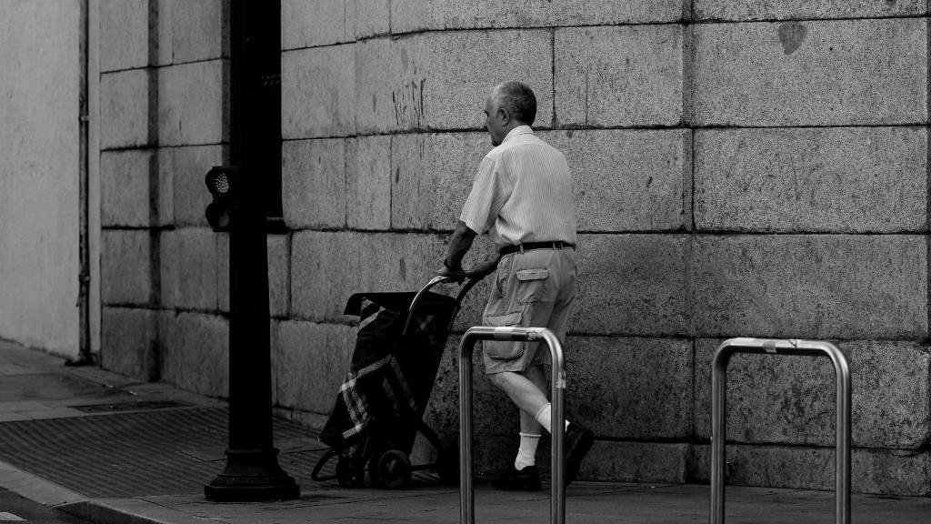 Un señor mayor camina por una calle de Madrid