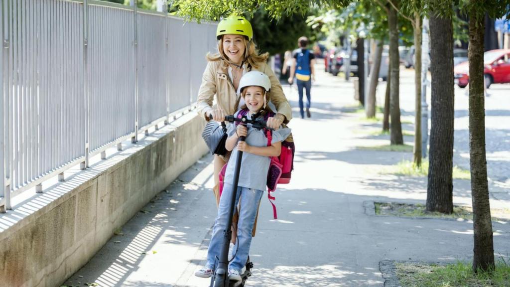 Una madre con su hijo en patinete.