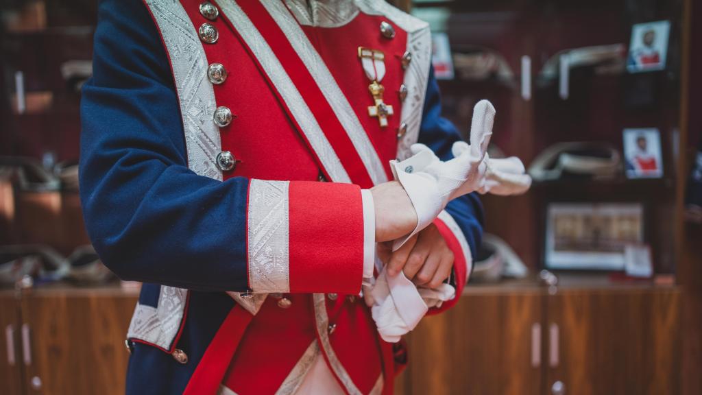 El guardia real Valenciano se enfunda los guantes blancos propios del uniforme de alabardero.