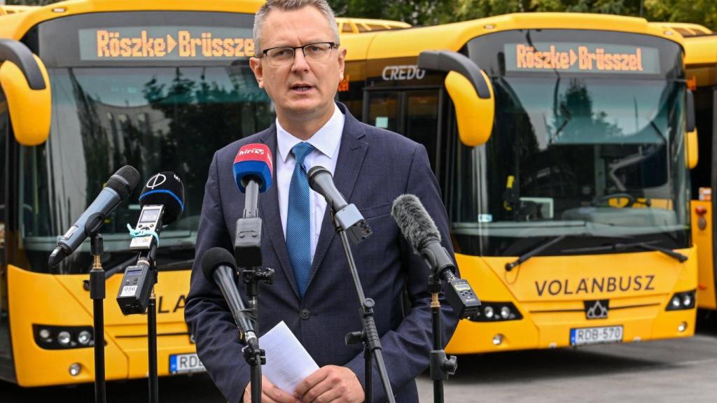 El secretario de Estado húngaro Bence Rétvári posa junto los autobuses que pretende enviar a Bruselas cargados de migrantes