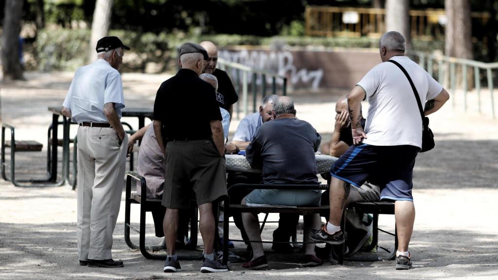 Varios pensionistas juegan al dominó en un parque de Madrid.