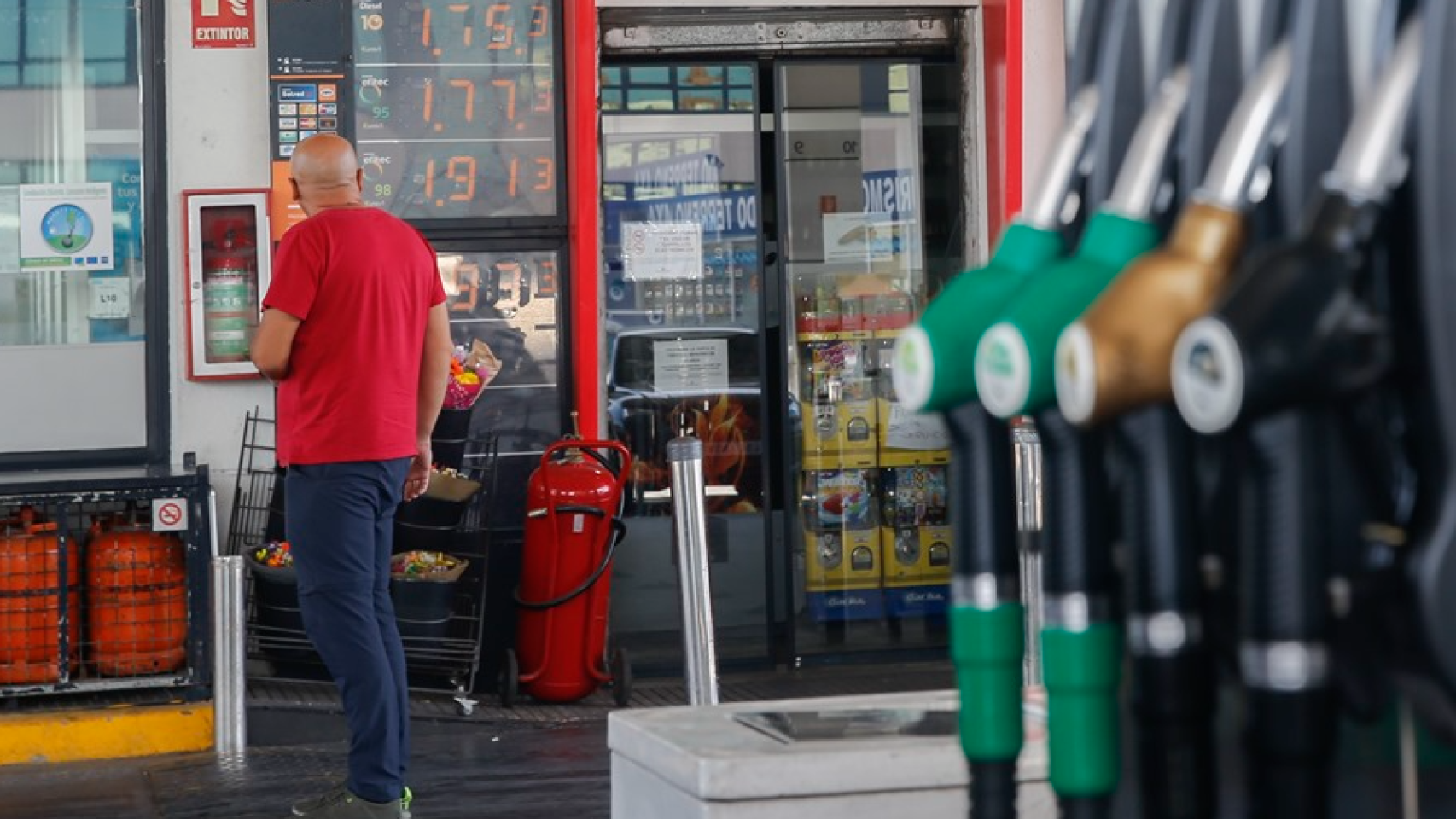 Un hombre mirando el precio de la gasolina.