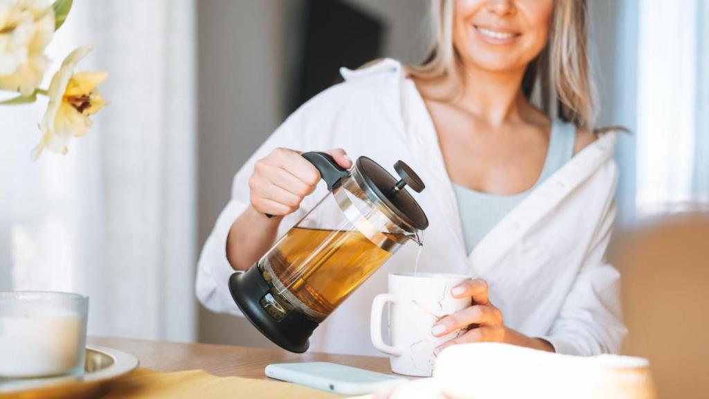 Mujer sirviéndose una infusión en la taza.