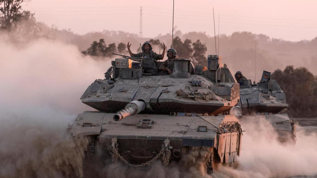 Un tanquista israelí saluda desde el carro de combate en una maniobra en la frontera con Gaza.