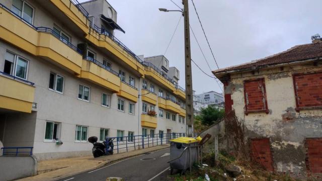 Un edificio residencial frente a una casa en ruinas en As Xubias de Abaixo.