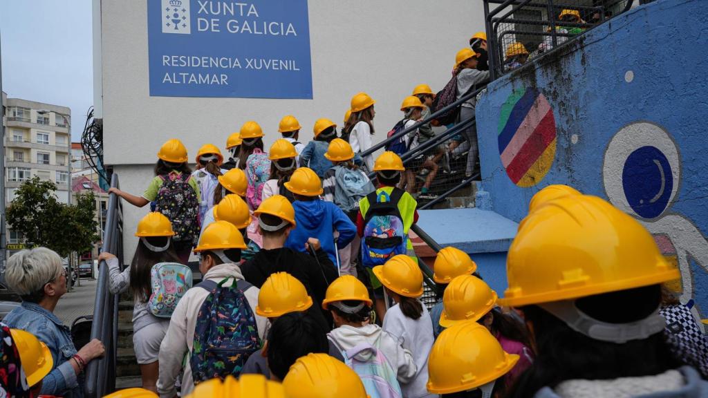 Imagen de niños accediendo al centro con cascos de protección