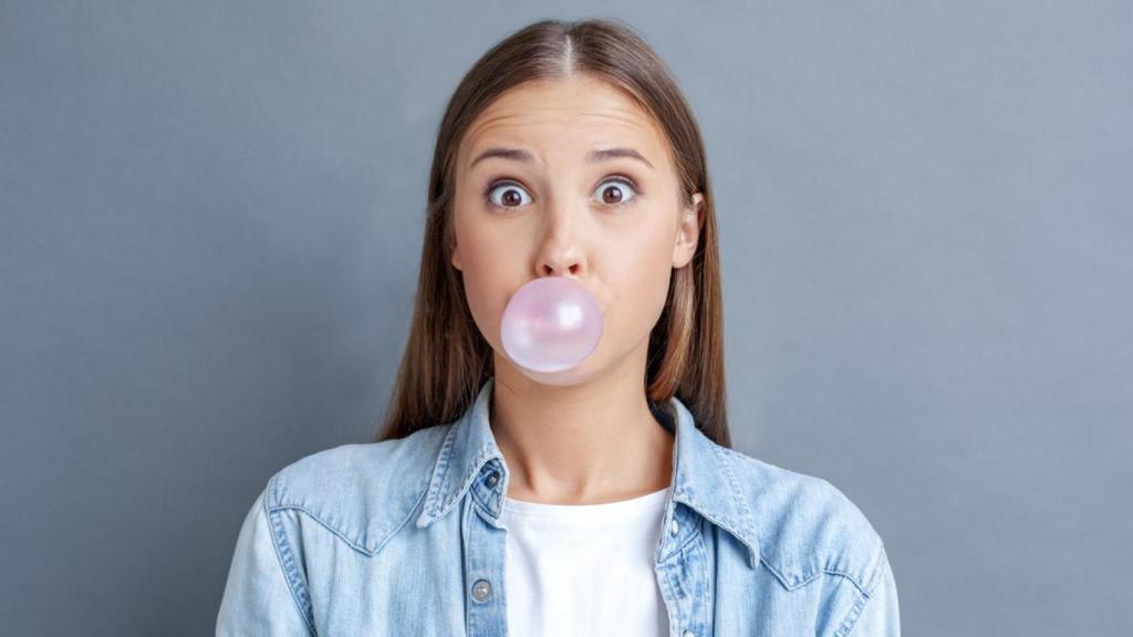 Mujer haciendo un globo con un chicle.