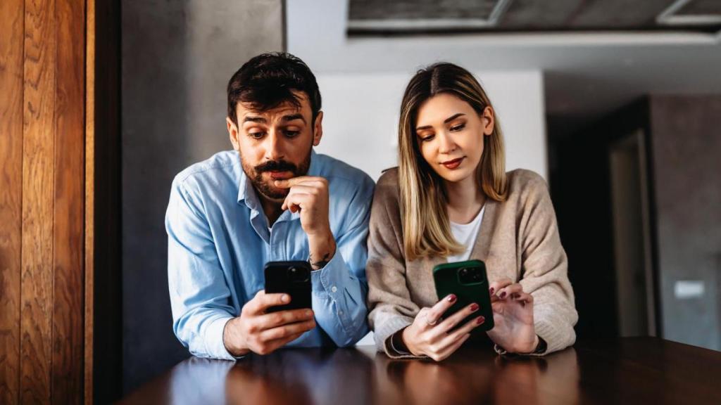 Pareja atendiendo a sus teléfonos.