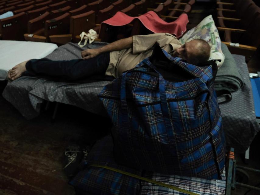 A man rests in the space reserved for evacuees.