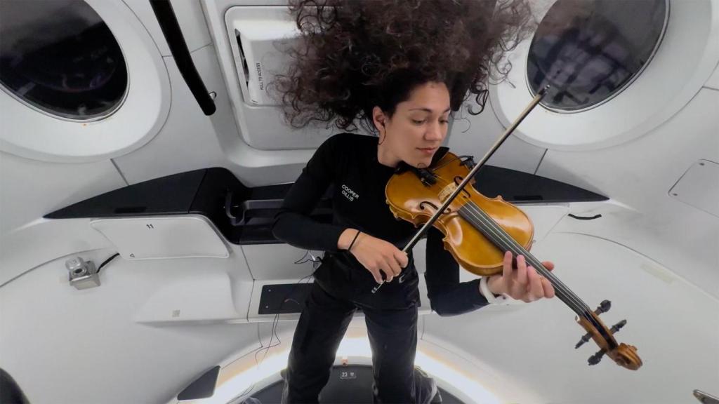 La ingeniera Sarah Gillis tocando el violín en la cápsula Dragon.