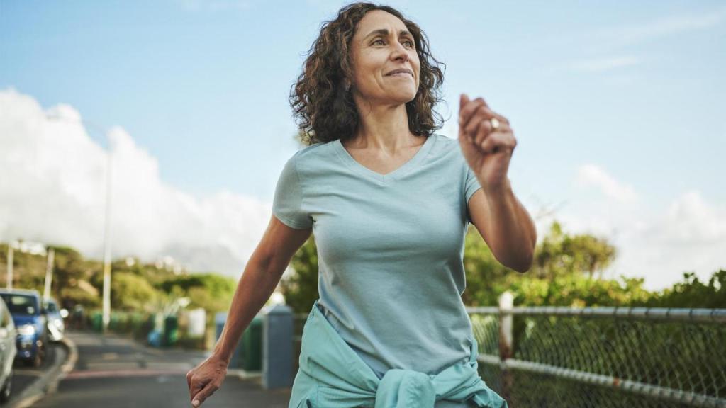 Mujer caminando sonriendo.