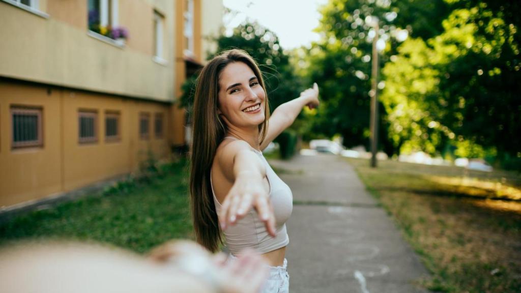 Mujer extendiendo la mano hacia otra persona.