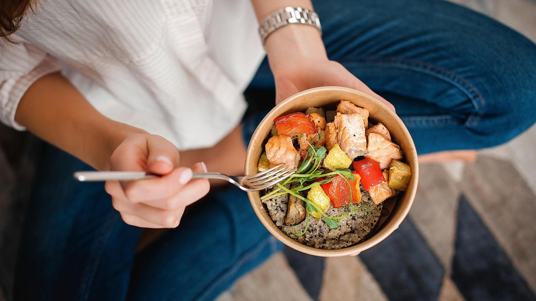 Una chica comiendo una ensalada, en una imagen de Shutterstock.