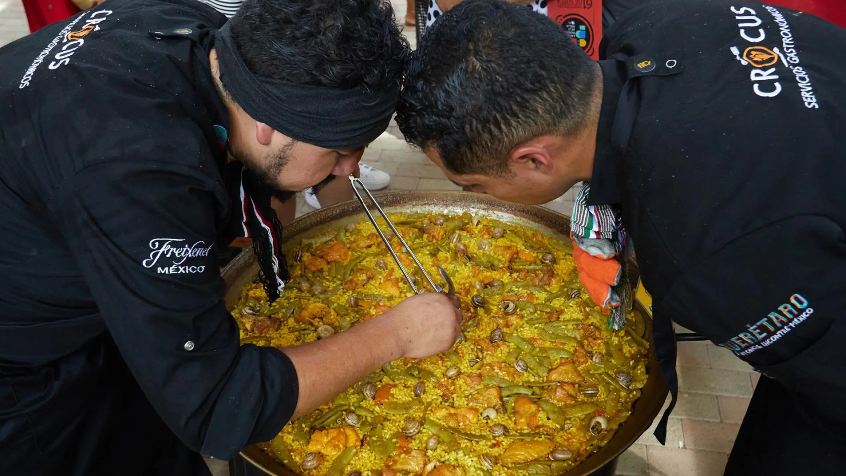 Dos chefs del Crocus Servicios Gastronómicos de México elaboran una paella. EFE/Natxo Francés