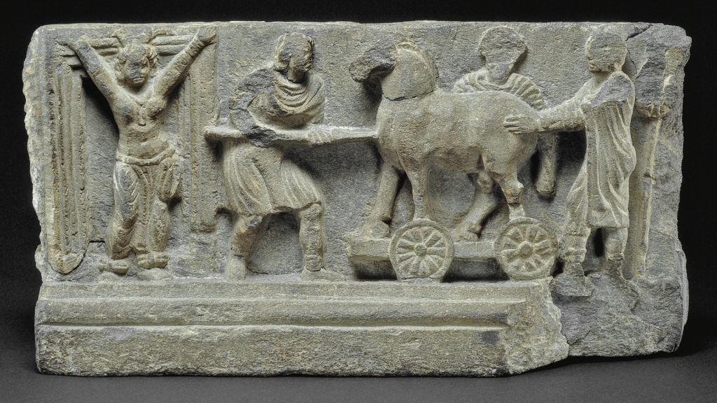 Arte de Gandhara, en Pakistán, de unos 500 años después de la conquista de Alejandro: la princesa Casandra intenta impedir que el caballo de madera entre en Troya.