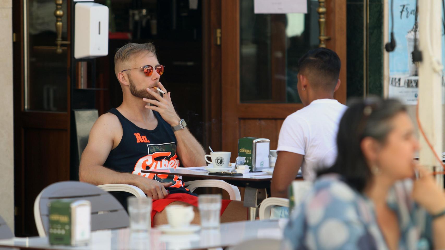 Una persona fumando en una terraza.