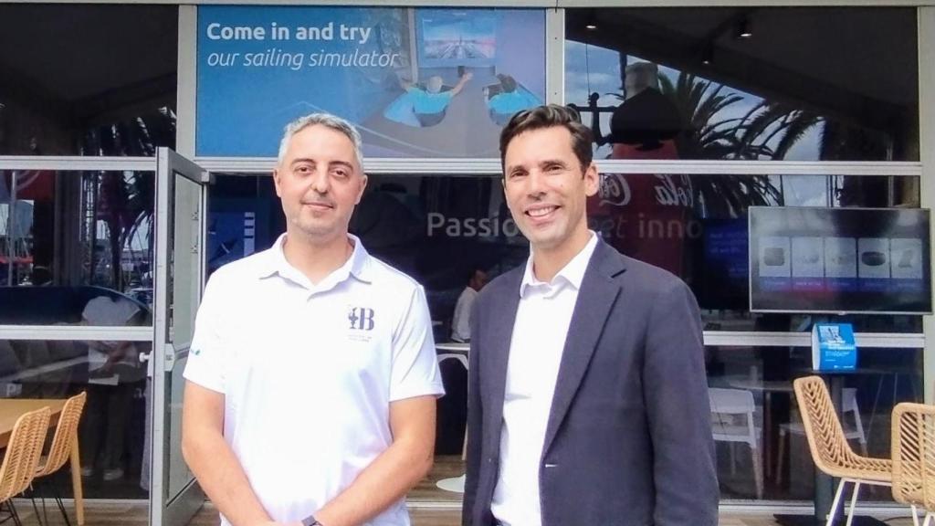 Xavi Navarro, XR Technical Lead de Capgemini Engineering España (izquierda) y Laurent Perea, director general de Capgemini Engineering España, en la entrada del stand del grupo situado en el Race Village de Copa América en Barcelona.