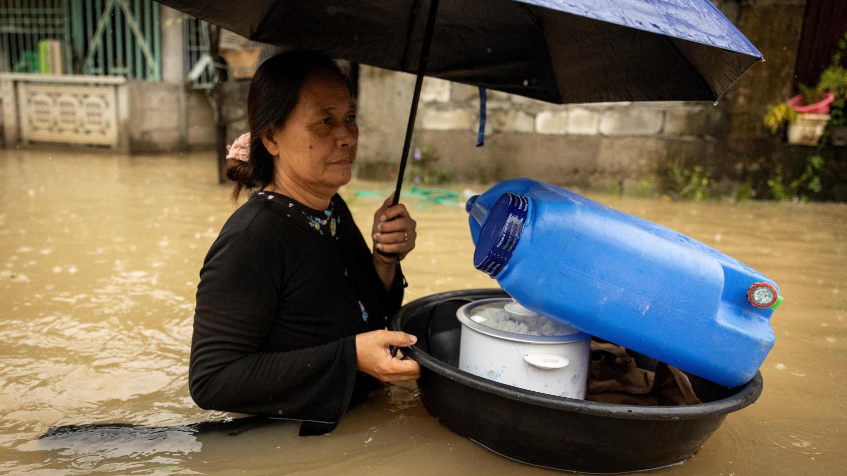 Una mujer traslada sus enseres tras los destrozos provocados por la tormenta Yagi en Filipinas.