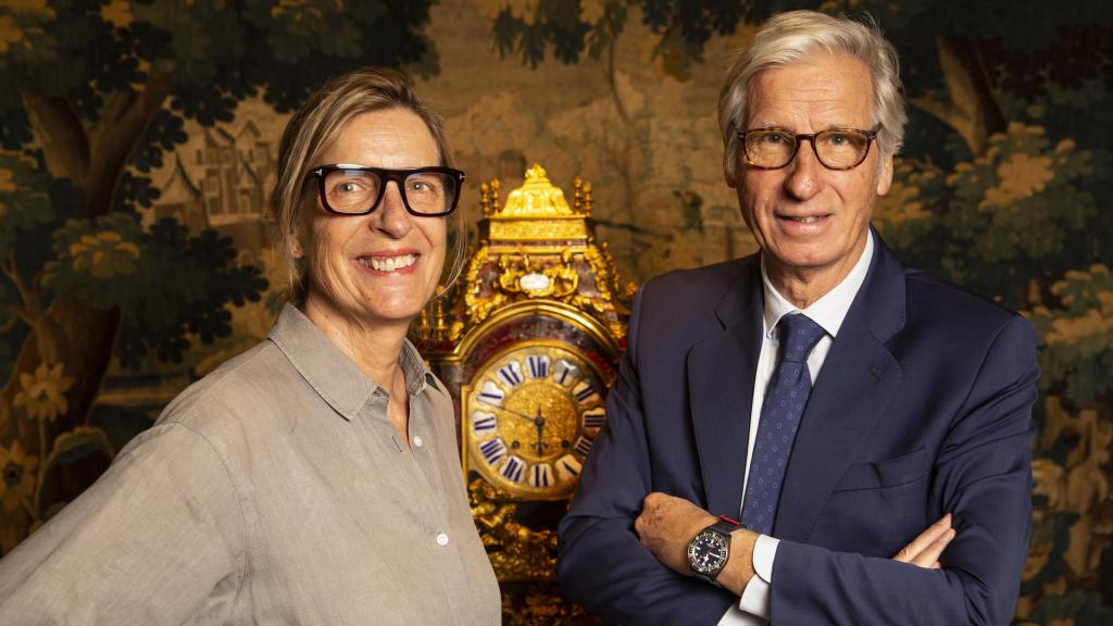 Yann y Patricia Reznak frente a uno de los relojes del Museo del Reloj Antiguo que hay en la planta baja de la joyería Grassy, en Gran Vía, 1.