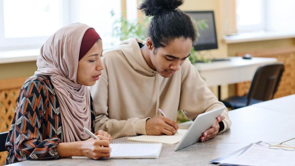 Dos migrantes estudiando