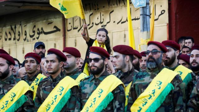 Una niña ondea una bandera frente a miembros de Hezbolá el día del funeral de tres miembros del grupo chií, el 21 de septiembre de 2024.