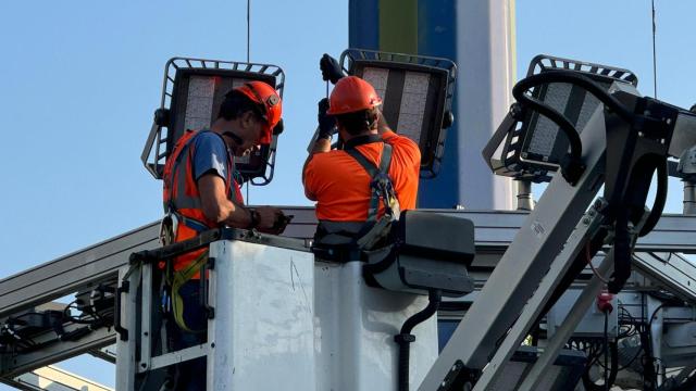 Dos trabajadores cambiando la iluminaria en el Puente de la Unión, en Zaragoza.