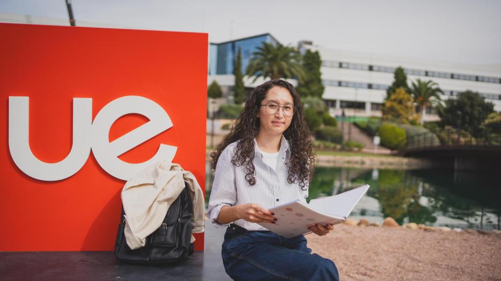 Waheda, con su mochila y sus libros enfrente de su universidad.