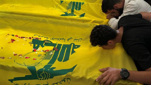 Gente llorando junto a los ataúdes de tres miembros de Hezbolá, que murieron en los ataques israelíes, durante su funeral en Saksakiyeh, en el sur del Líbano.