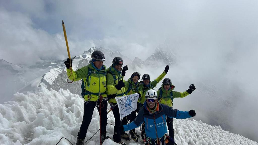 Los cinco expedicionarios posan en la cumbre con el director de la expedición, Carlos Martínez.