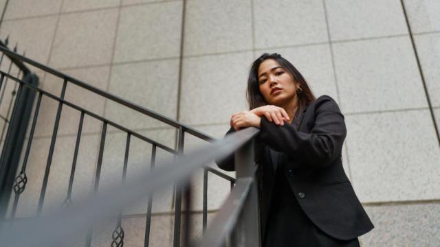 Mujer con ropa de color negro en una escalera.