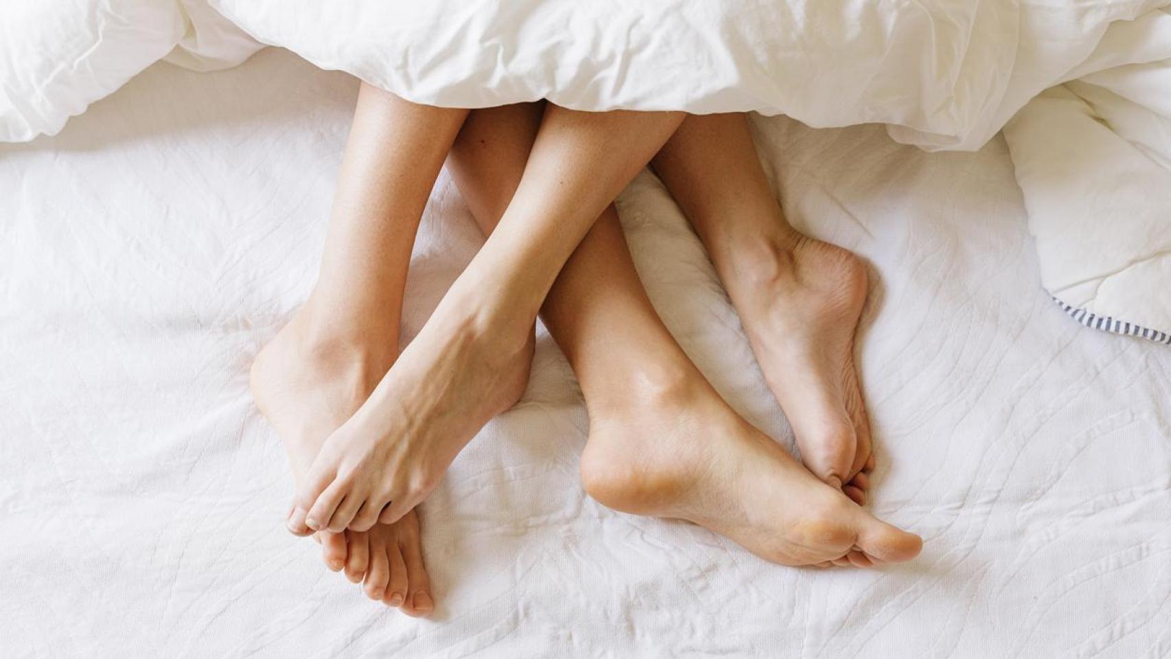 Pies de una pareja en la cama.