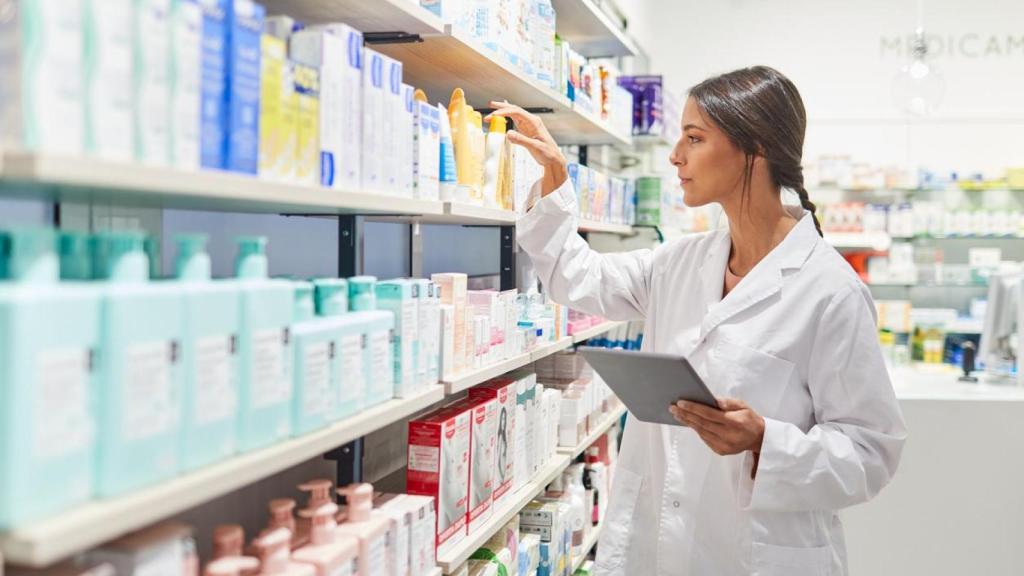 Una farmacéutica atendiendo a un cliente.