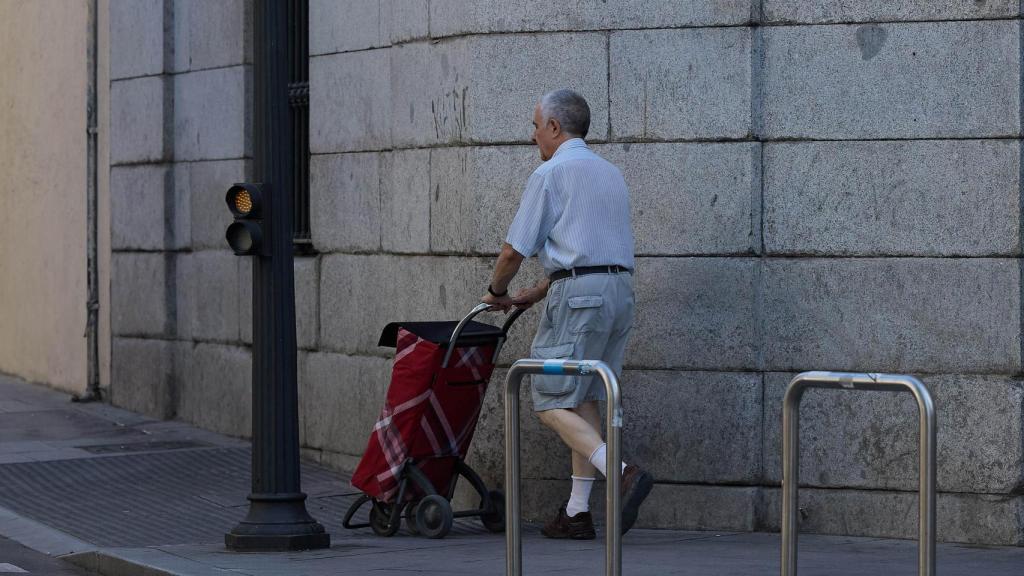 Un señor mayor camina por una calle de Madrid.