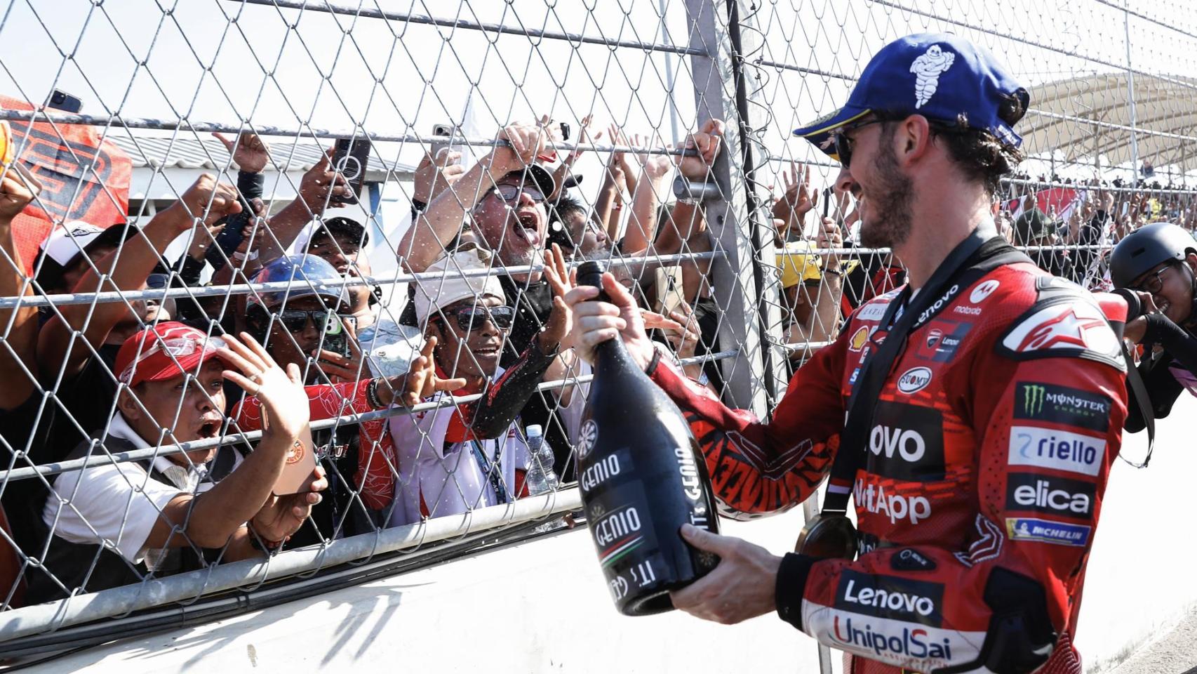 Pecco Bagnaia riega con champán al público presente en el circuito de Mandalika, en Indonesia.