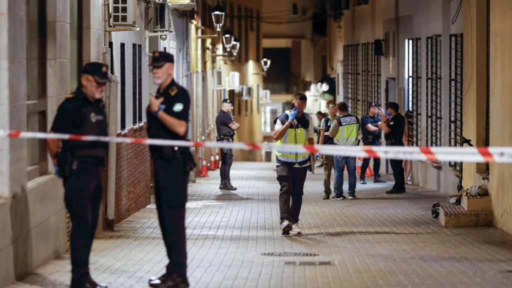 Agentes de policía cercan la calle donde se ha producido un tiroteo en el que varias personas han resultado heridas este sábado por la tarde en Málaga capital.