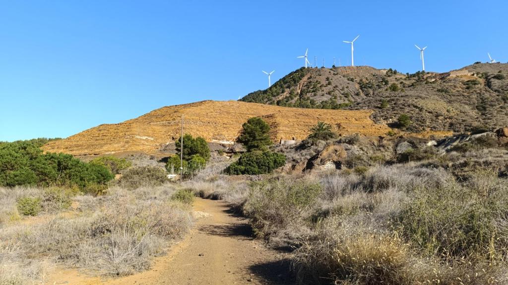 Una gran terrera de residuos mineros se levanta junto a la carretera que conecta El Llano del Beal con La Unión.