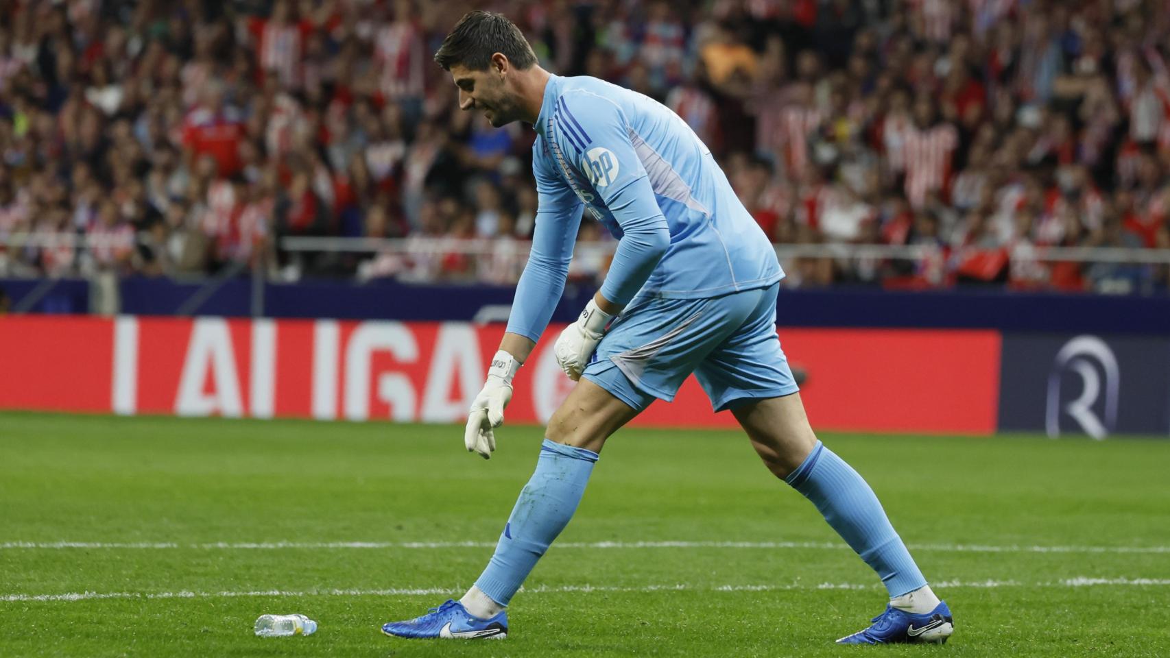 Courtois recoge una botella que le lanzaron desde el Fondo Sur del Metropolitano.