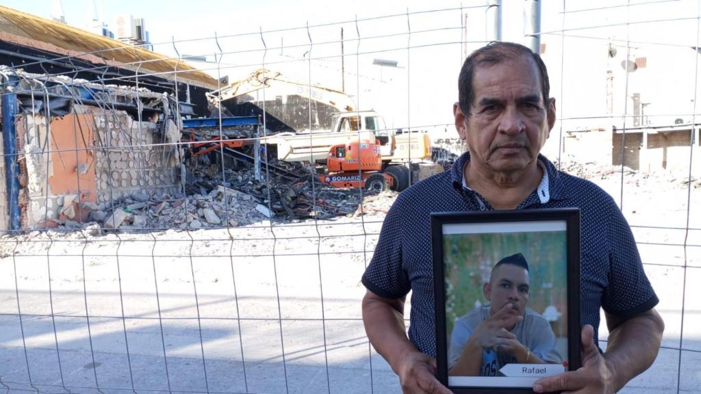 Rafael Miranda, este martes, mostrando una foto de su difunto hijo, Rafael, junto a la demolición de la Discoteca Teatre y Fonda Milagros.