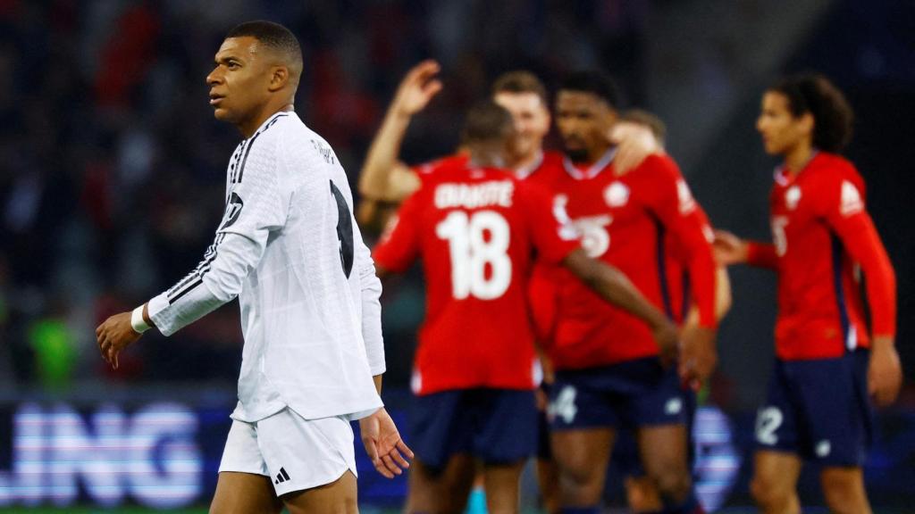 Mbappé, con la mirada perdida mientras los jugadores del Lille celebran.