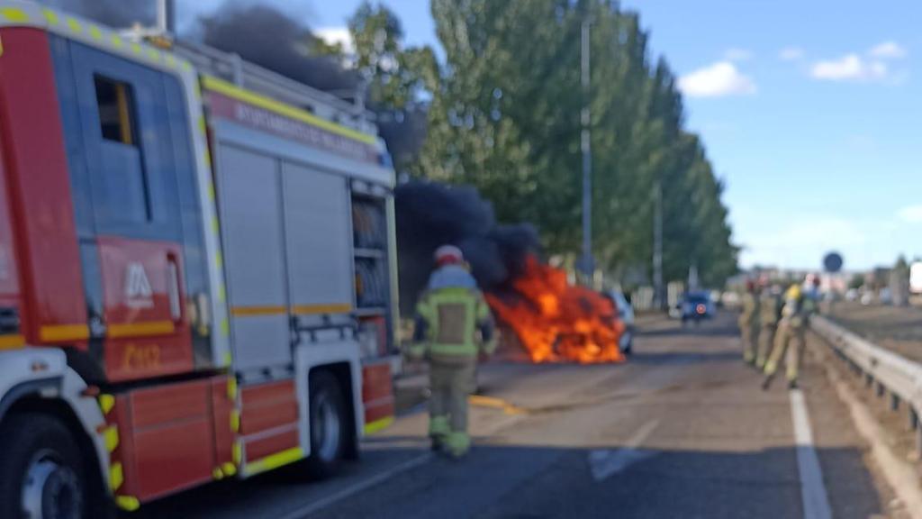 Los bomberos con el vehículo que se ha incendiado