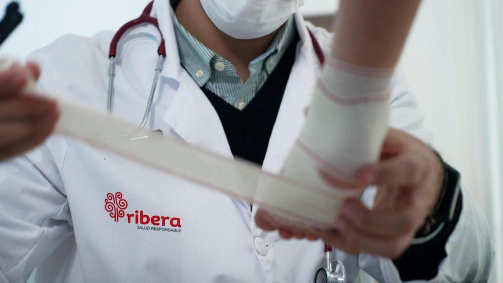 Profesional sanitario de Ribera atiende a paciente de Traumatología. Grupo Ribera