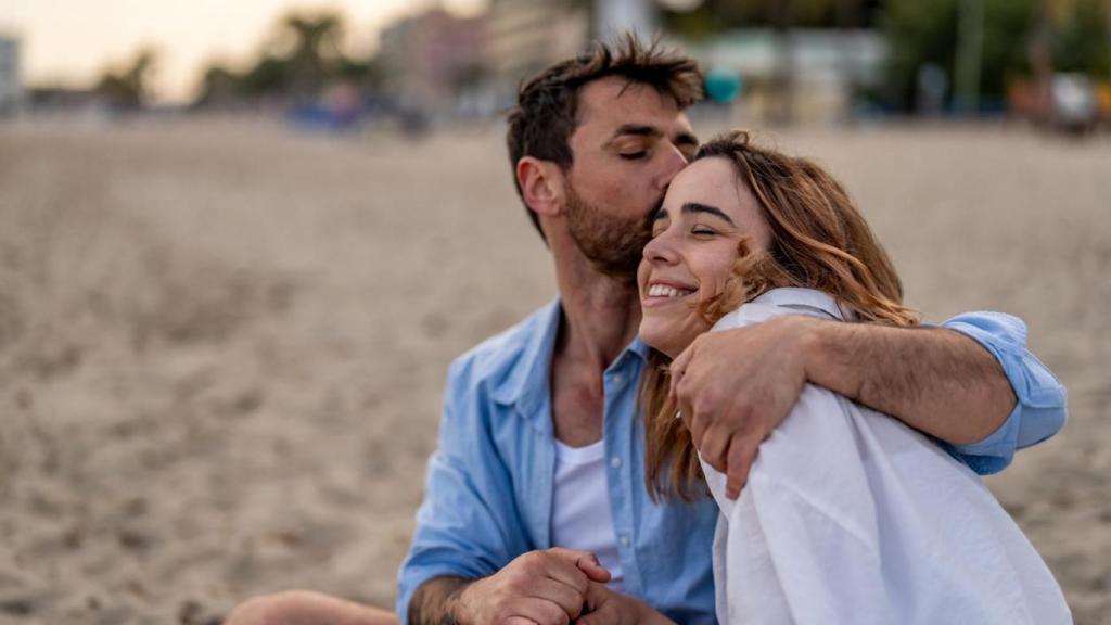 Pareja abrazada en la playa.