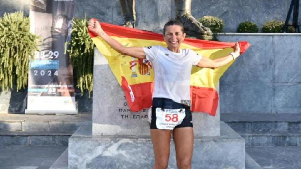 Carmen, con la bandera de España junto a la estatua de Leónidas.