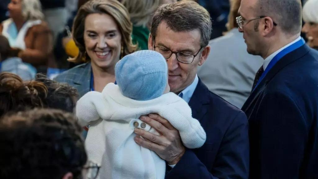 Alberto Núñez Feijóo sujeta a  un bebé, junto a Cuca Gamarra, en un acto del PP en Valencia.