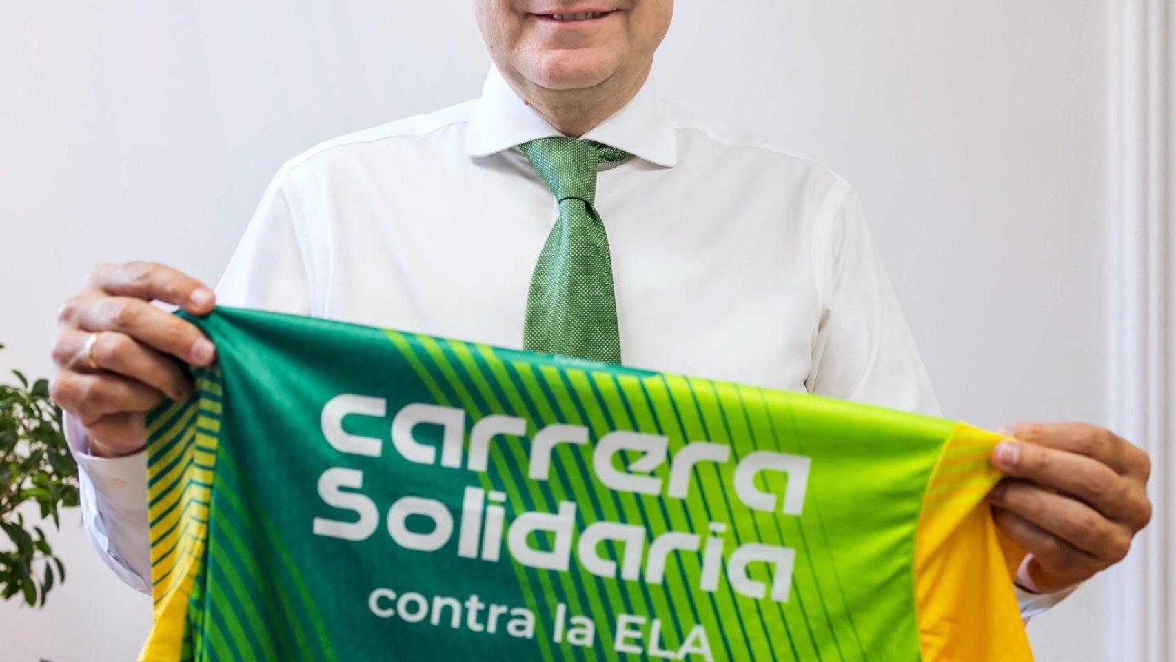 El presidente de la Junta, Alfonso Fernández Mañueco, sostiene la camiseta de la Carrera Solidaria contra la ELA