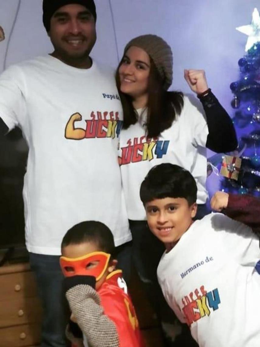 José y Tatiana posando con camisetas de Super Lucky en Navidad, junto a sus hijos, Luciano, disfrazado de superhéroe, y su hermano mayor, Juan.