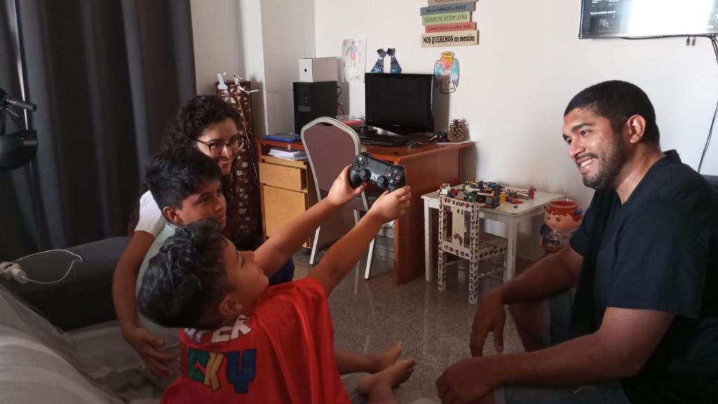 Luciano, con su capa de Super Lucky, este viernes, jugando con su hermano y sus padres en el salón de su piso en Molina de Segura.