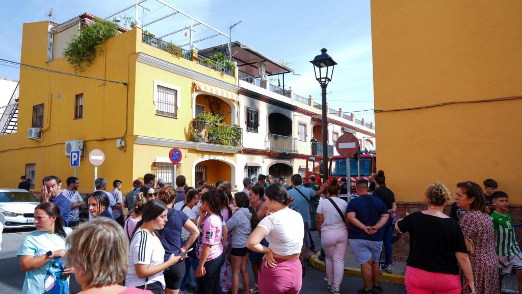 Un grupo de vecinos se concentran frente a la casa donde fallecieron los cuatro miembros de la familia.