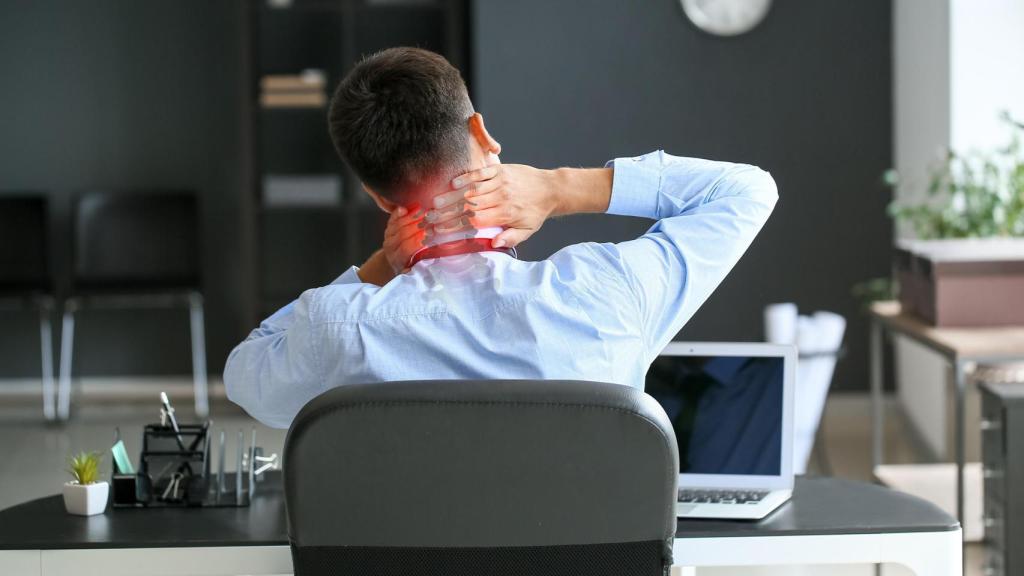 Una persona se queja del dolor de espalda, en una imagen de Shutterstock.