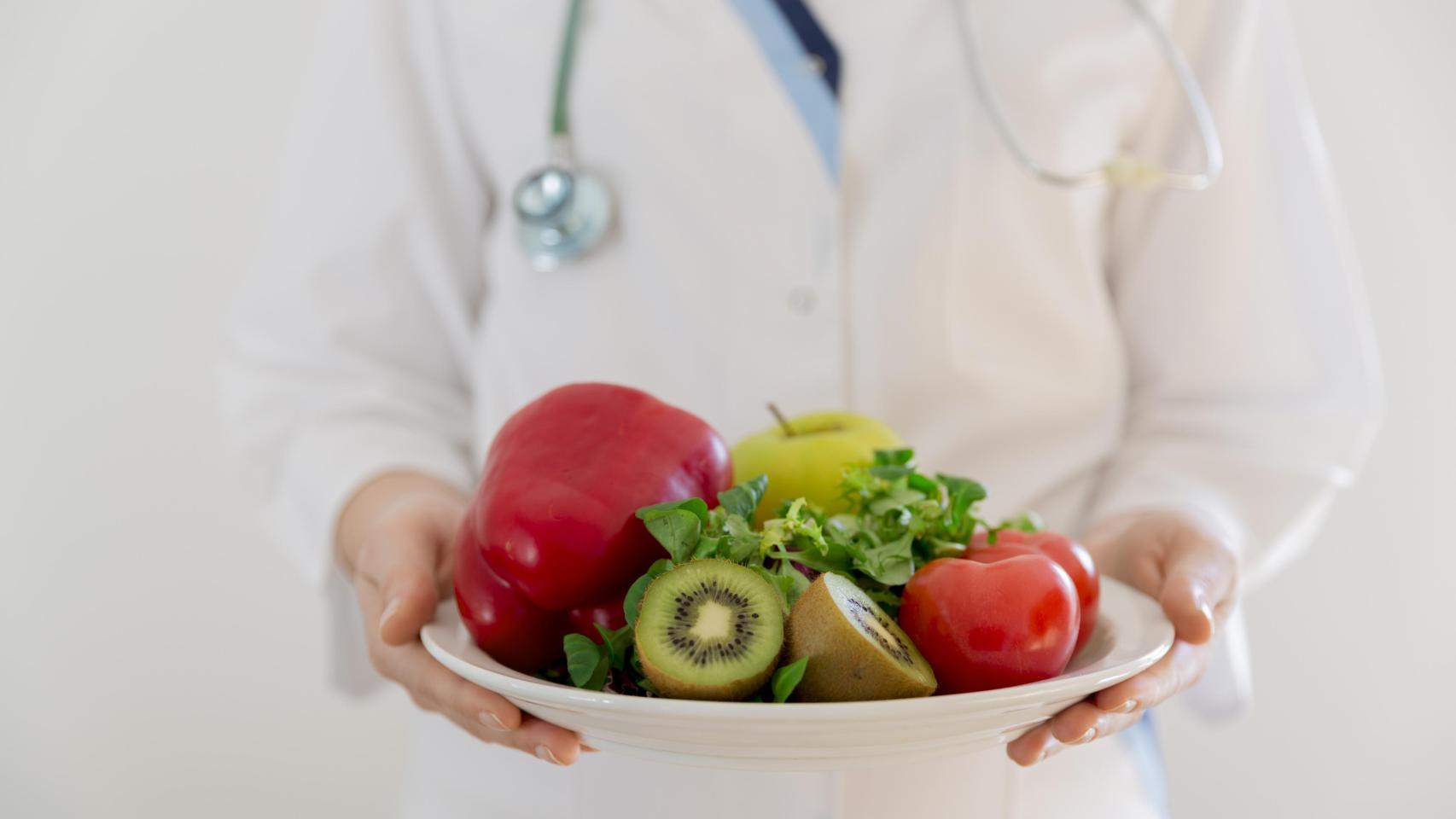 Un médico con un plato de alimentos.